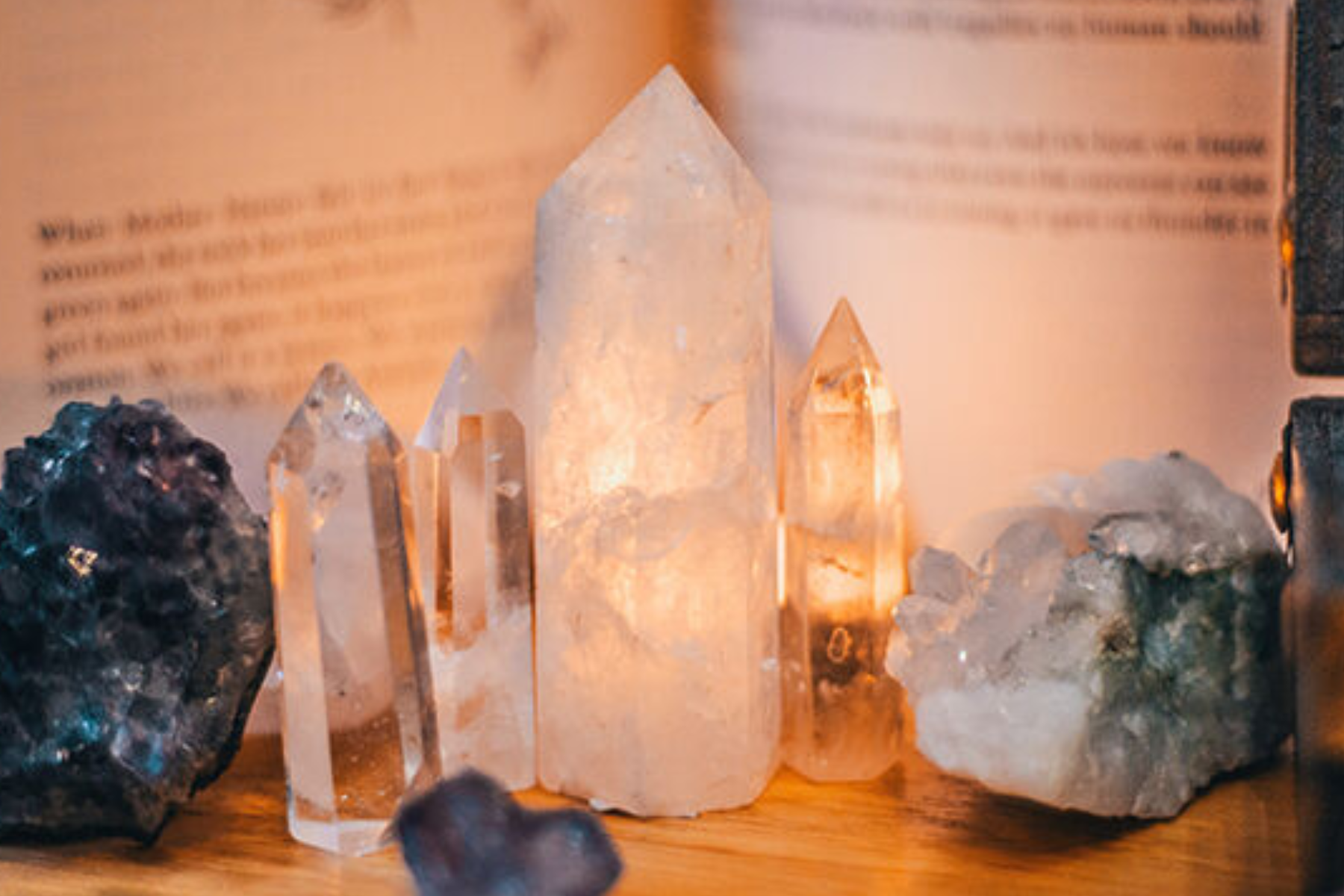 A collection of crystals on a table in front of a ritual book