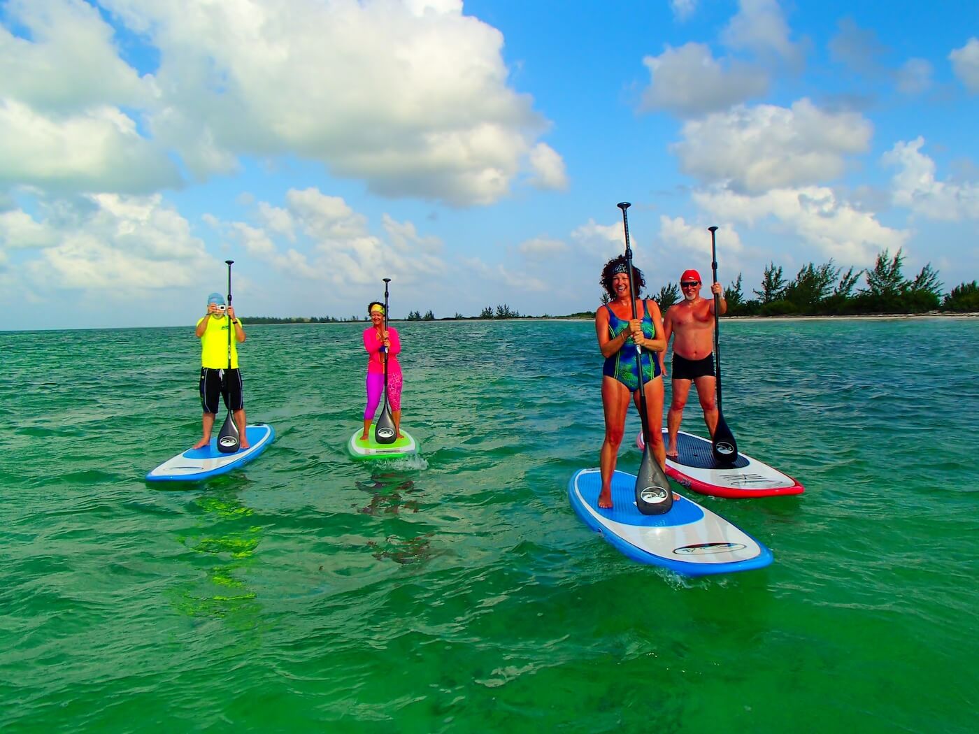 Four people stand-up paddleboarding