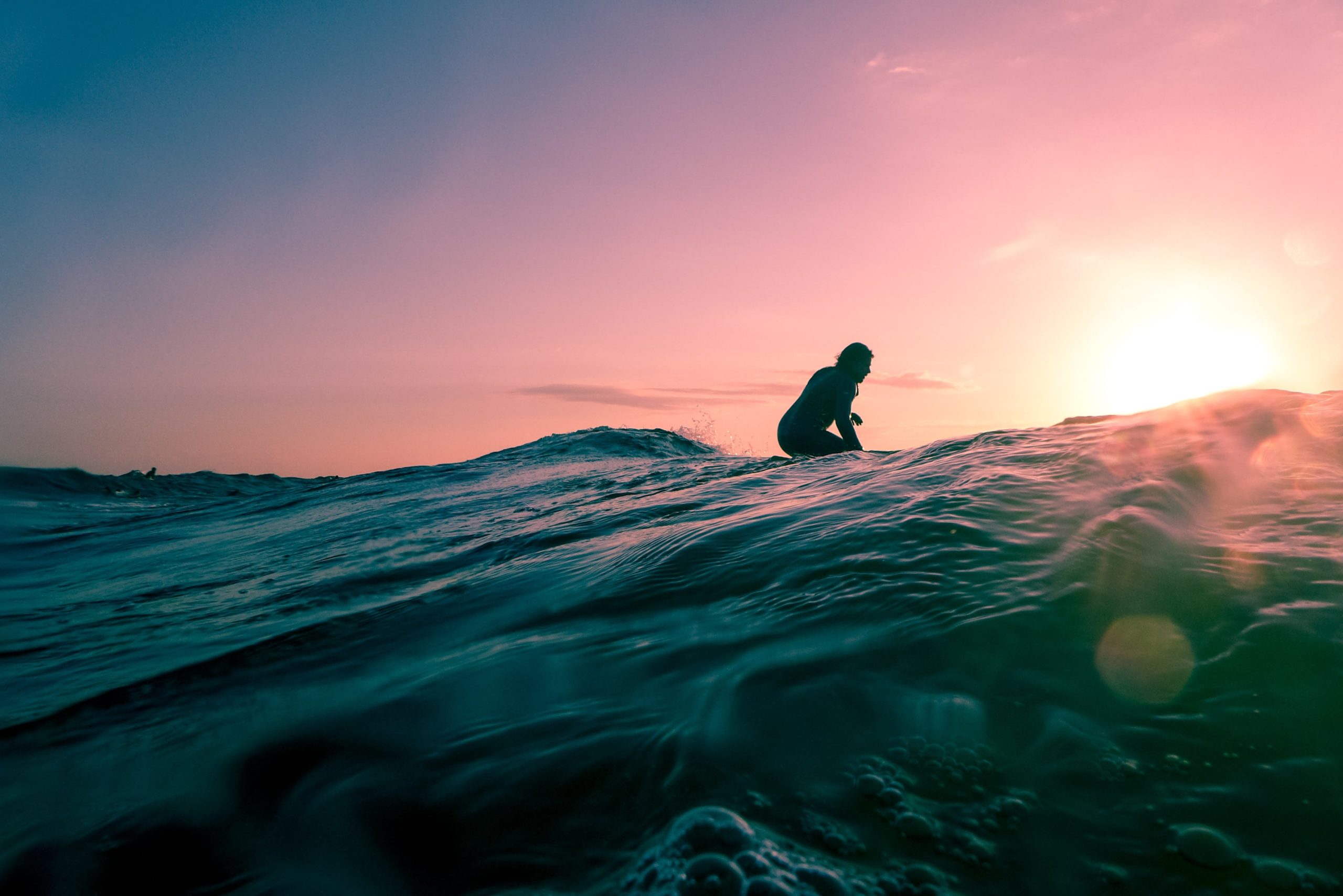 Person surfing at sunset