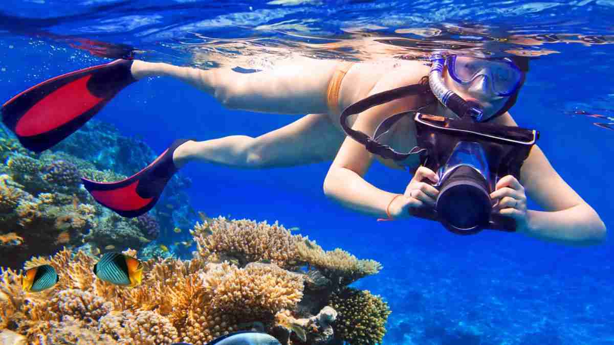 A kid holding a camera while snorkeling.