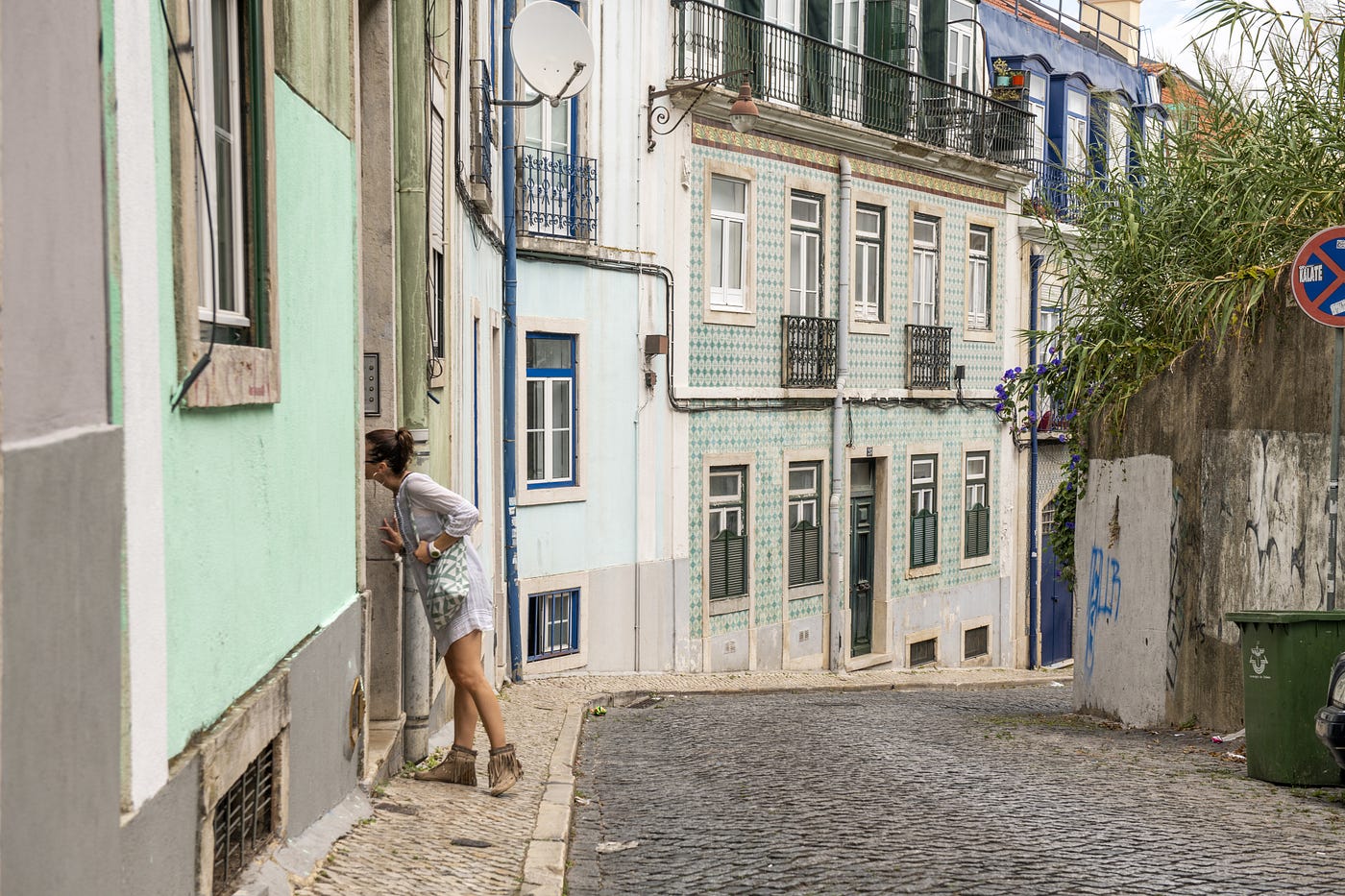 Woman peeking through a house in Portugal.